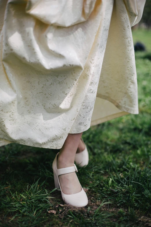 the legs and shoes of a woman dressed in white