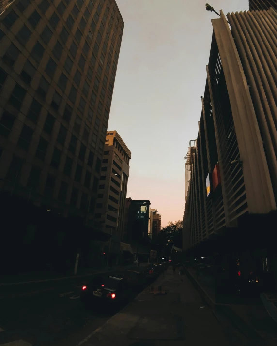 a city street with cars and tall buildings