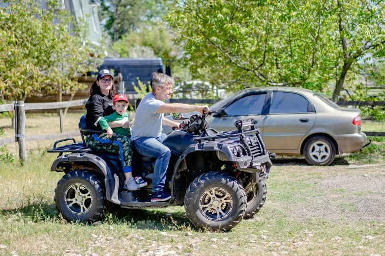 a couple is riding on the four wheeler