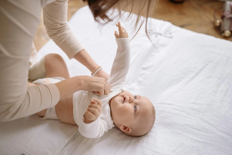 a mother puts the arm of a newborn baby