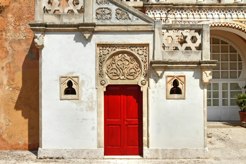 a building with an ornate red door, and ornamental architecture