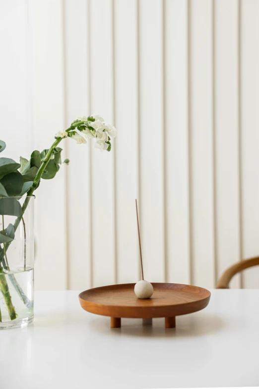 a vase of flowers with an incense rod and stick in front