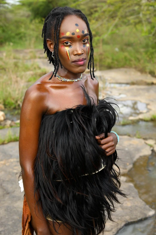 a young woman in tribal garb on rocks