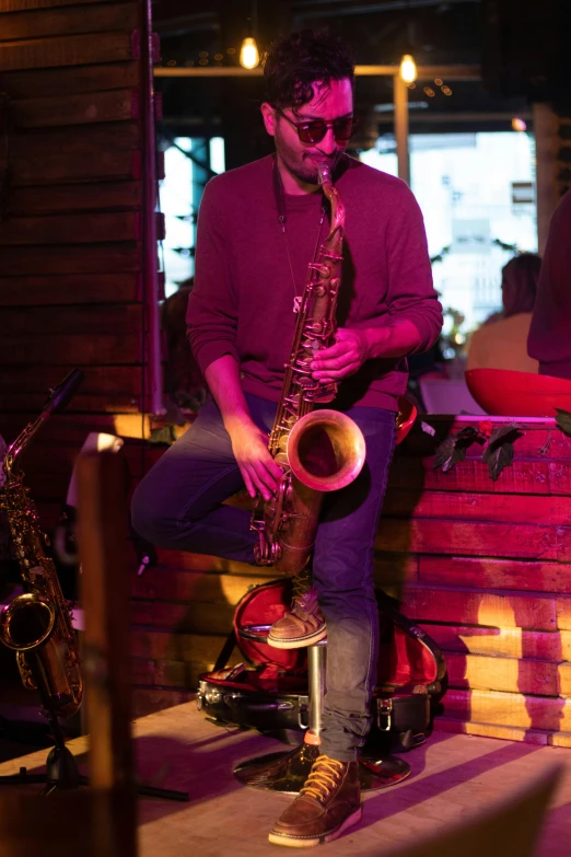 a man with glasses is playing the saxophone
