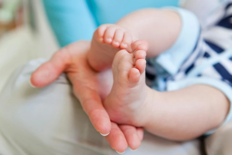 a baby with a big, fluffy foot in a bed