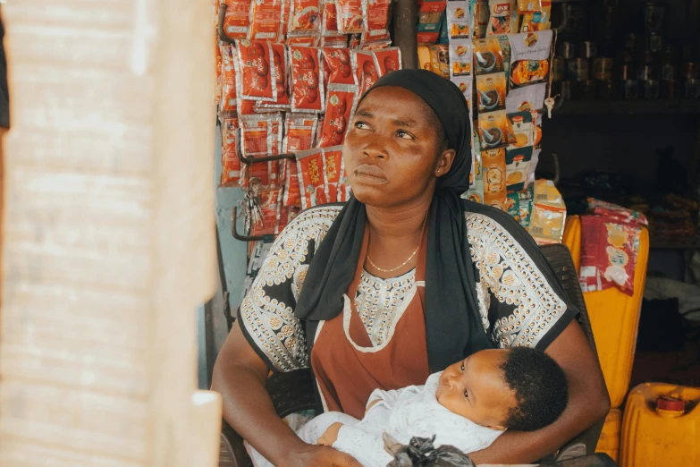 woman holding a baby in front of several bags