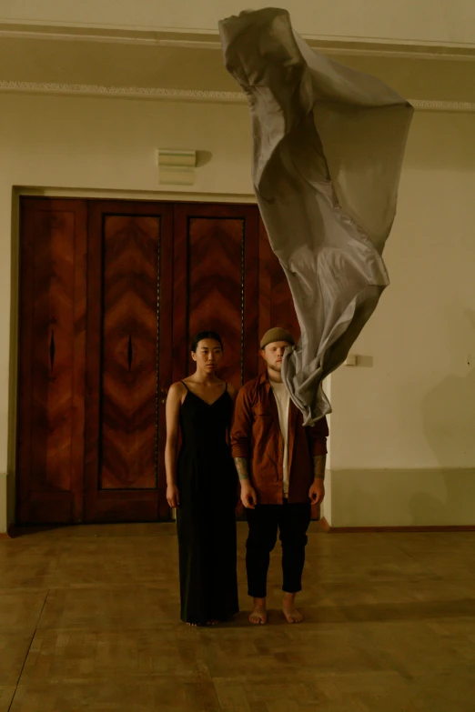 two people standing with a curtain wrapped around them