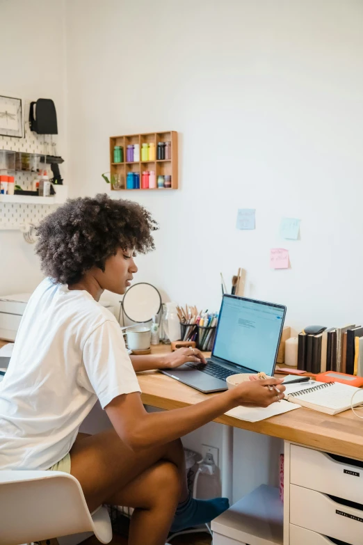 a person sitting at a desk with their laptop