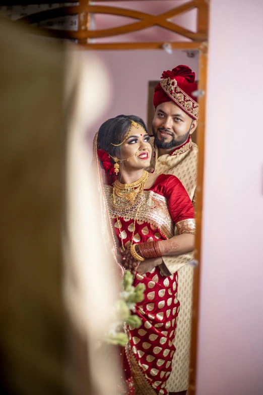 couple in bridal gown standing together posing for a pograph