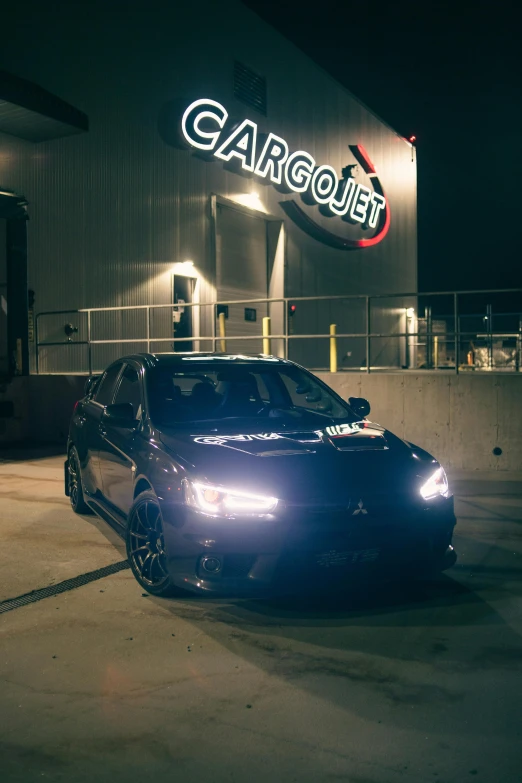 a car parked in front of a garage sign at night