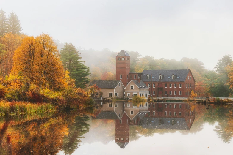 a large brown house surrounded by a lake