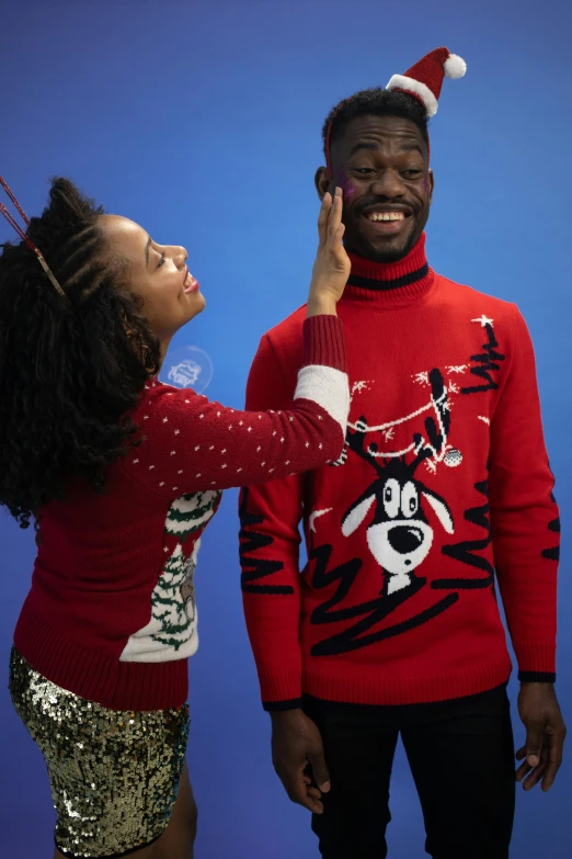 a man in a christmas sweater is talking on a cell phone