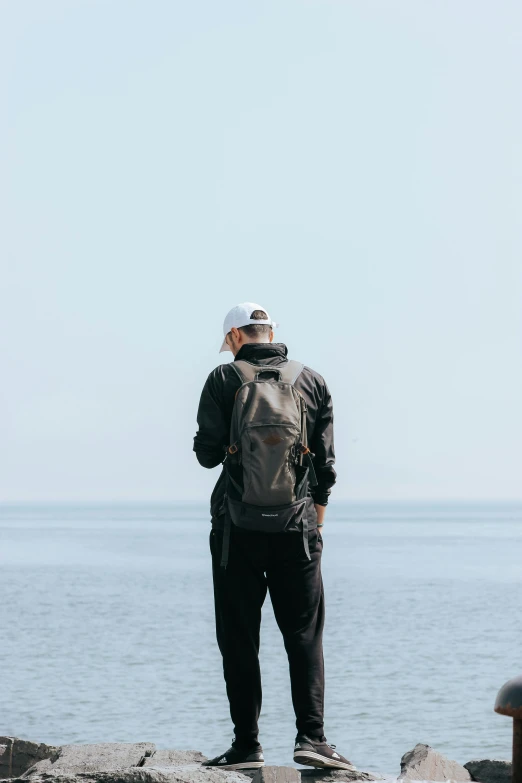 a man standing on top of rocks near the water