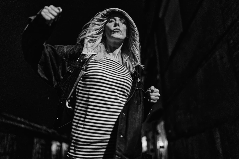 a woman is standing with her arms up and is holding a skateboard