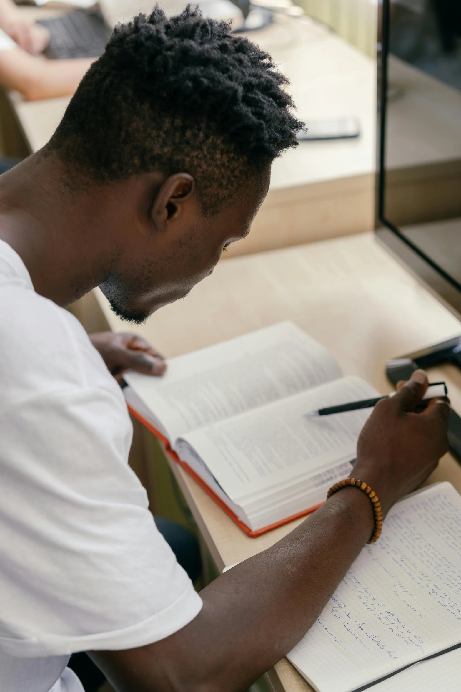 a man is holding a book while writing on a clipboard