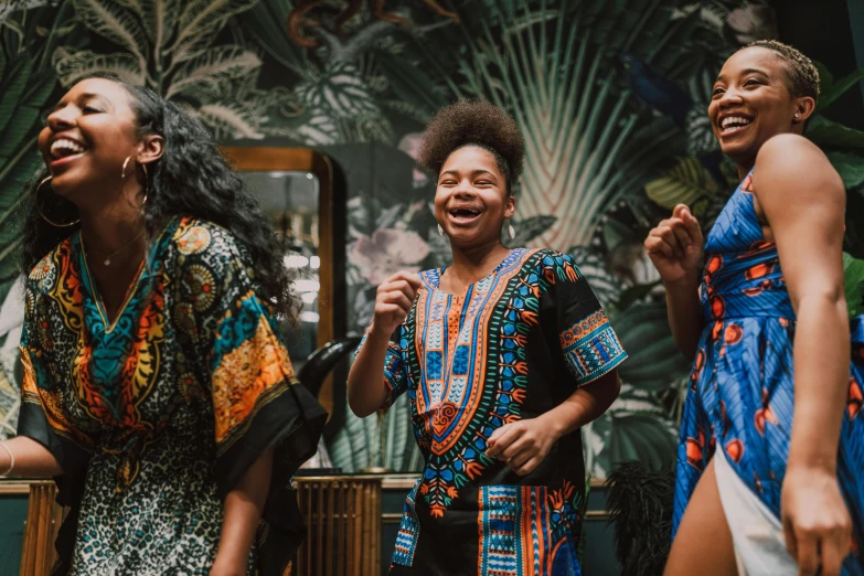 three ladies all laughing and singing while standing together