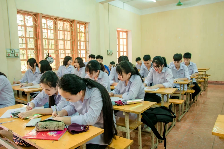 a classroom of s at desks writing