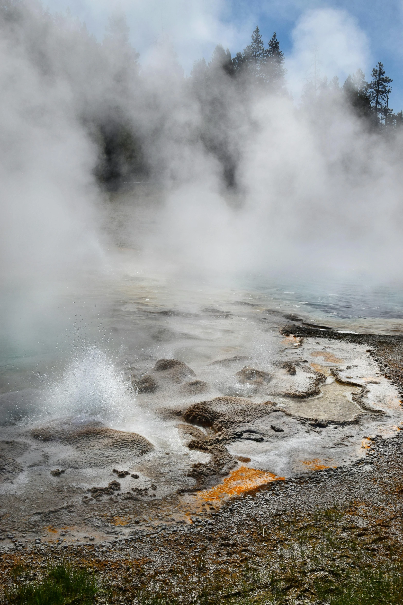 a water fall on a field with lots of steam