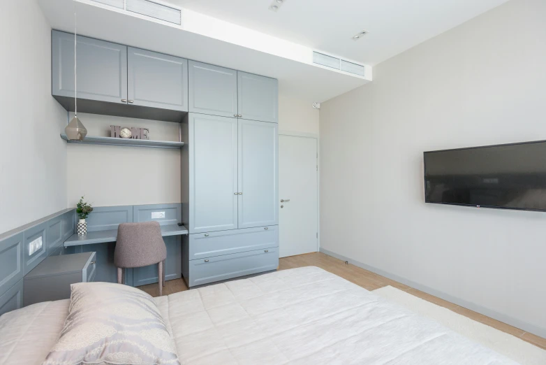 a bed sitting under a flat screen tv