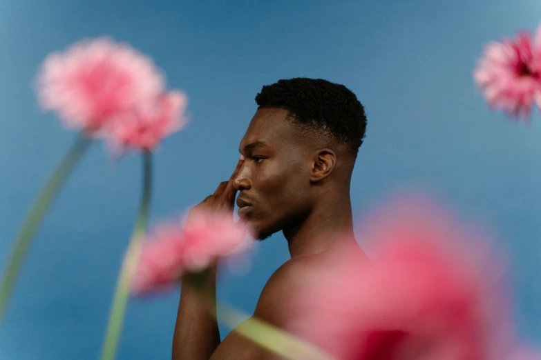 man in black underwear surrounded by pink flowers