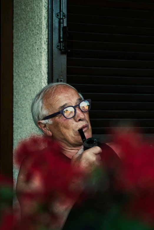 a man holding a pipe and wearing glasses