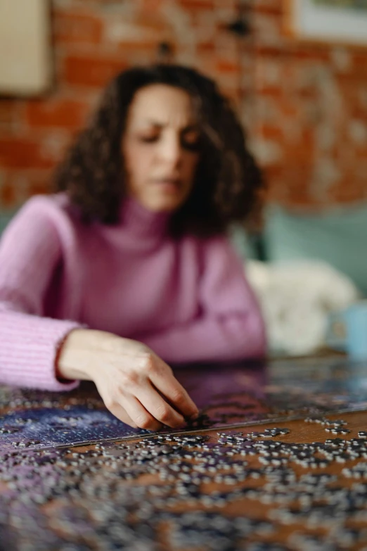 a woman is sitting at a table on a puzzle