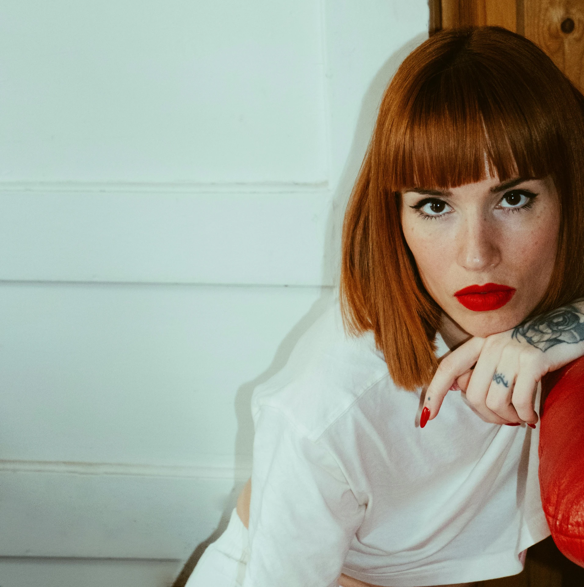 a girl with red lips sitting on a chair