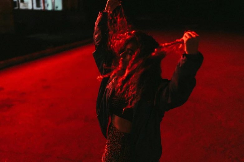 woman with hand raised looking to screen on tv