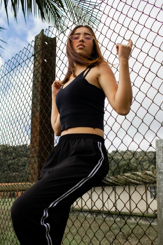 a girl standing in front of a fence