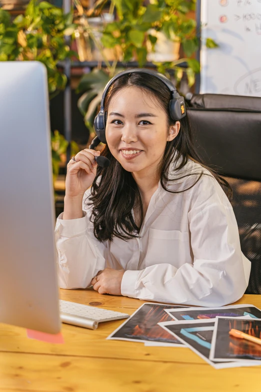 a woman is sitting at a table with her headphones on