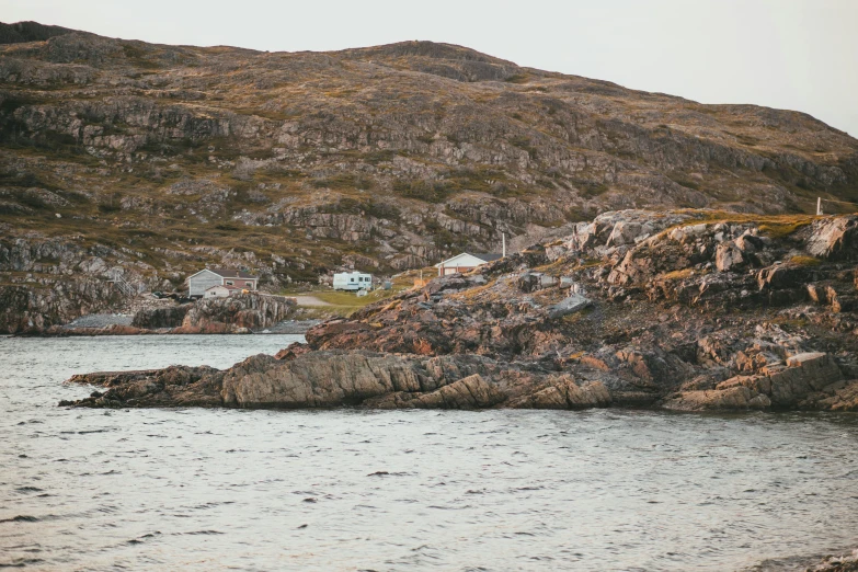 a rocky coastline with two houses near the shore