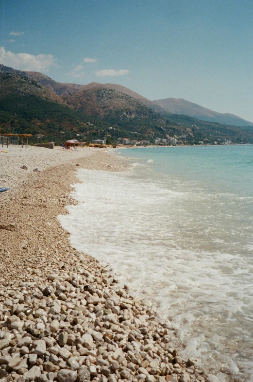 there is rocky beach and some water next to the shore