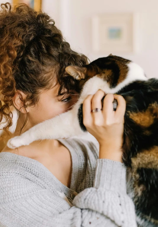 a woman holds her cat up to the camera