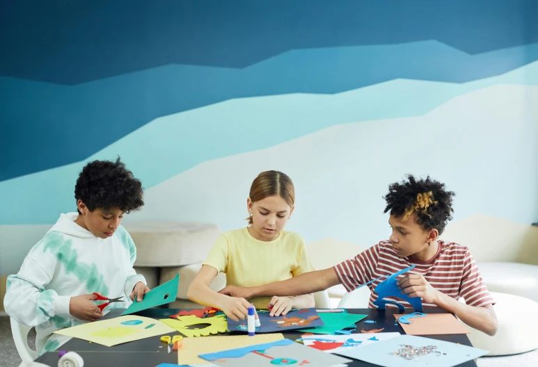 two children doing art work on a paper