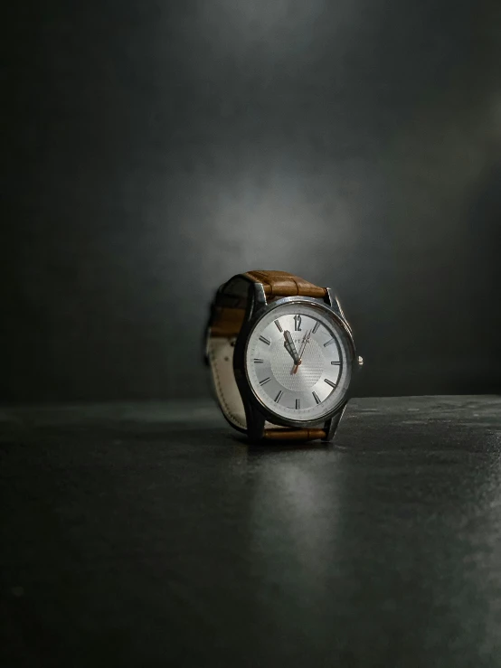 a watch sitting on top of a black table