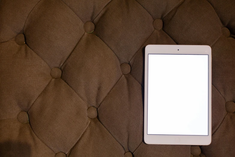 a tablet that is sitting on top of an ottoman