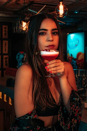 a young lady in a lingerie is sitting by a drink