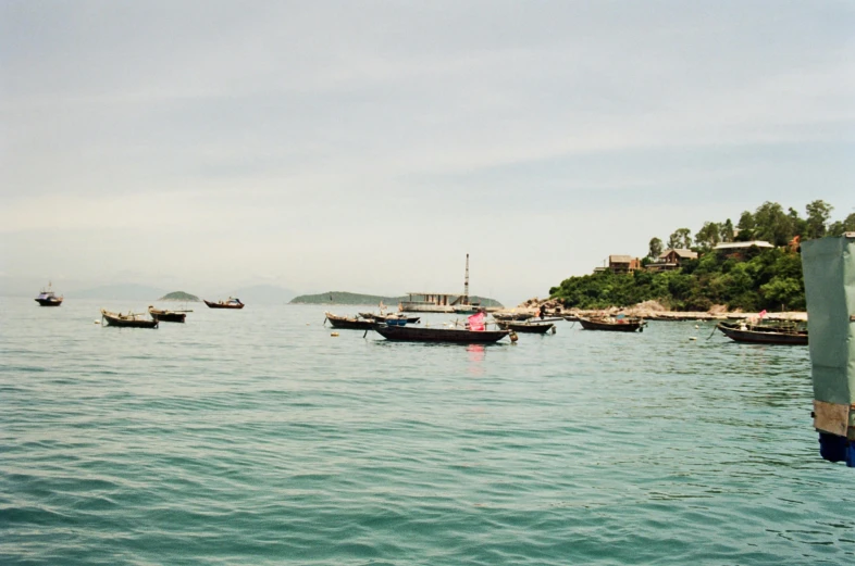 several boats are in the ocean on a calm day