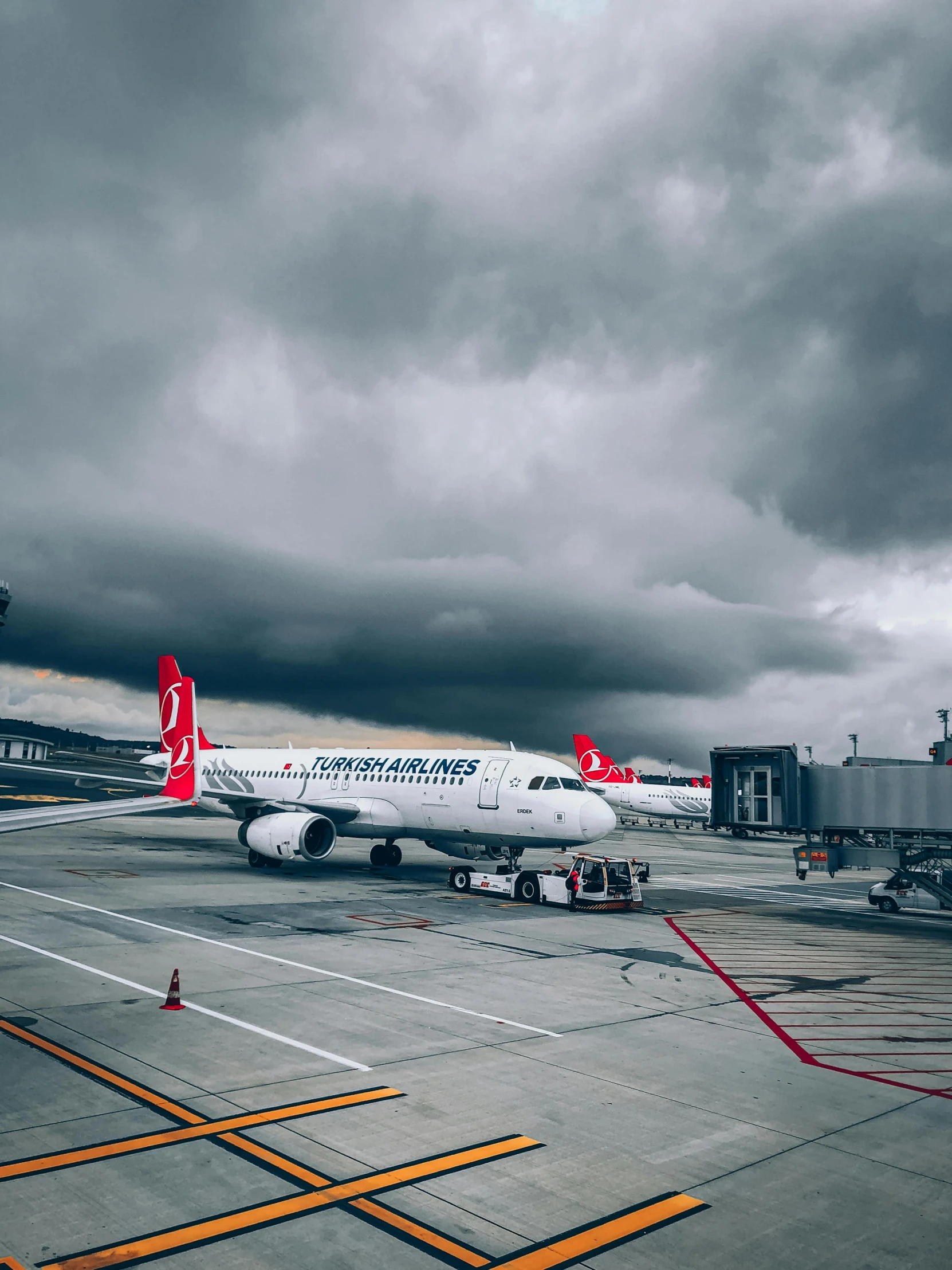 a large white airplane with a red tail sitting on the tarmac