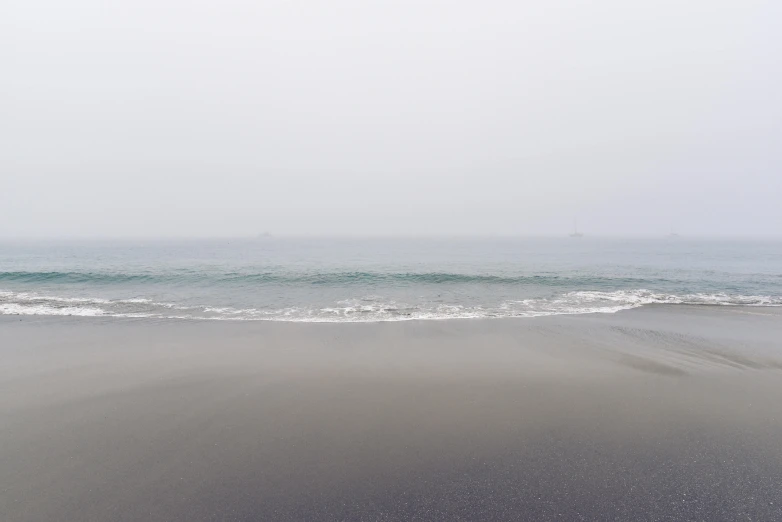 a wet beach and the water of the ocean