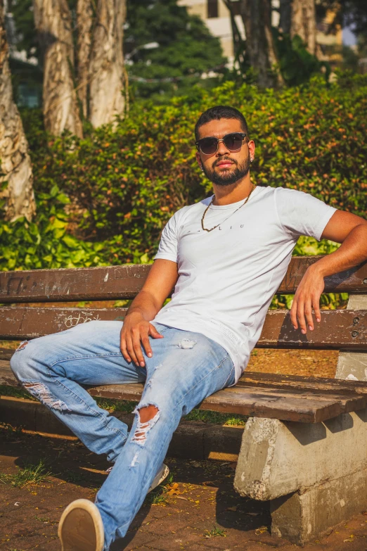 a man sitting on top of a wooden bench