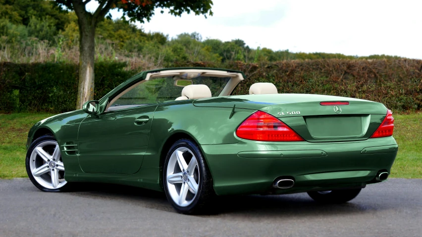 a green sports car is parked in a driveway