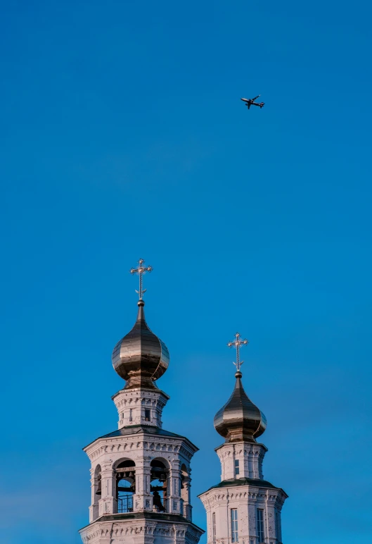 the large airplane is flying over two ornate structures