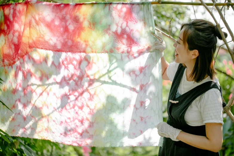 a woman is holding an old piece of cloth with her fingers