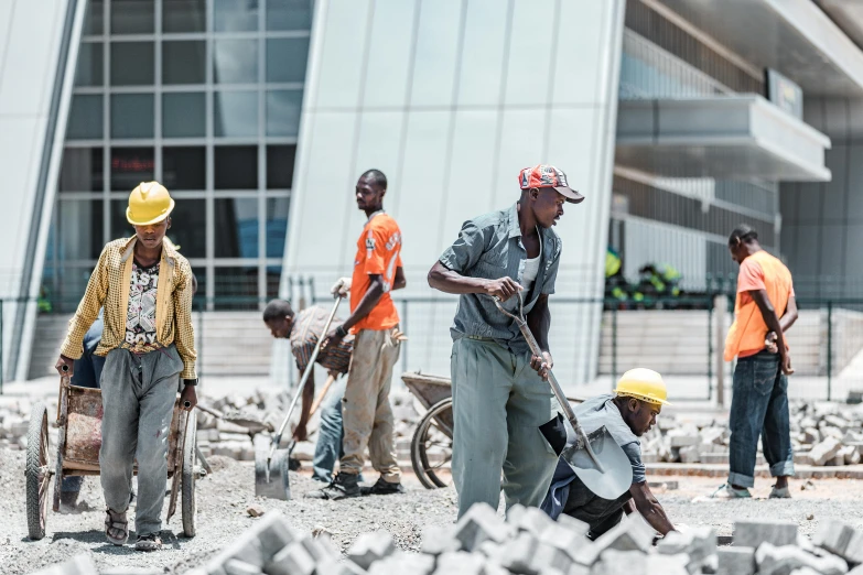 a group of men with shovels working on a pile of rubble