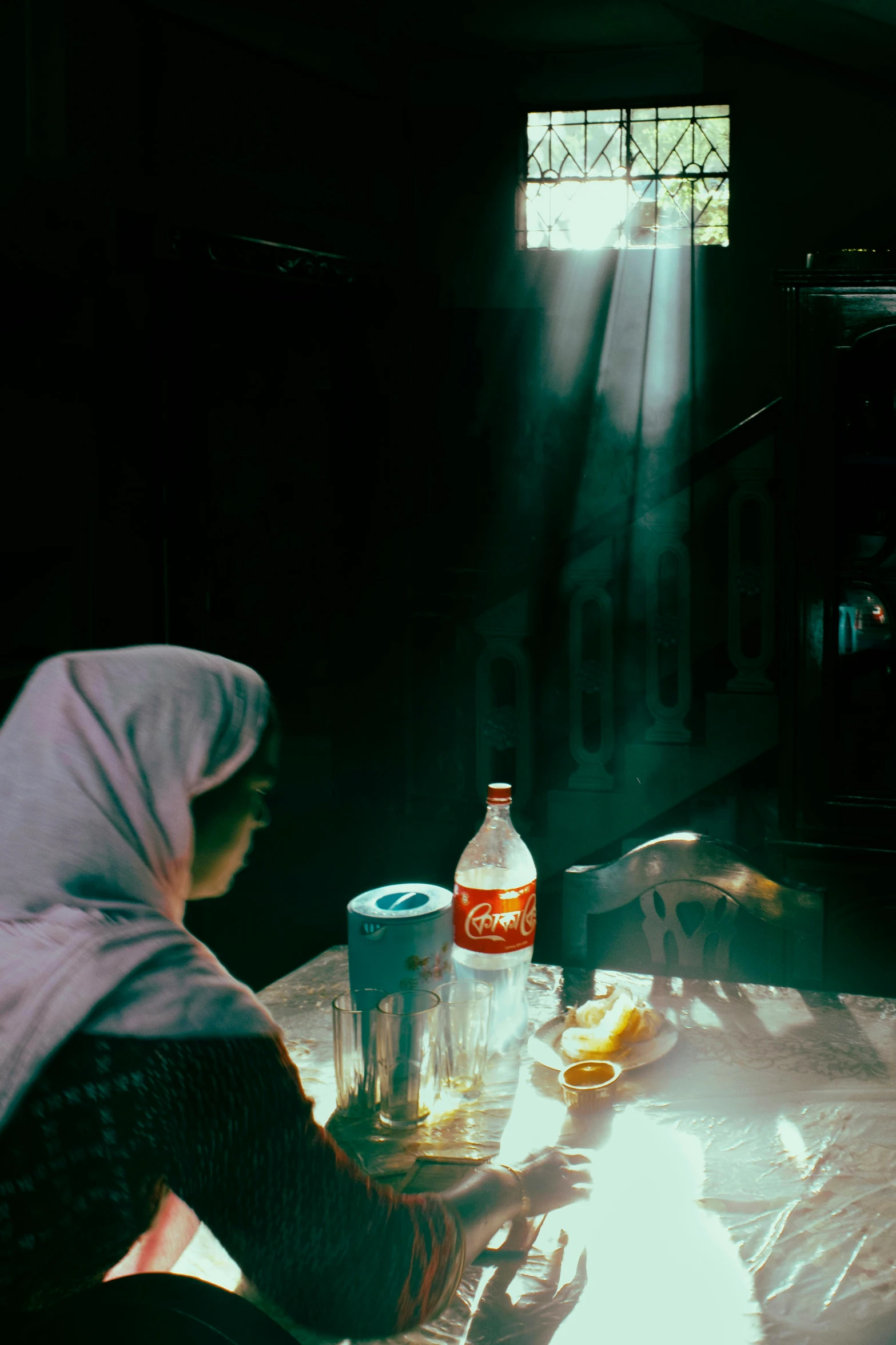 a person sitting at a table with bottles and glasses