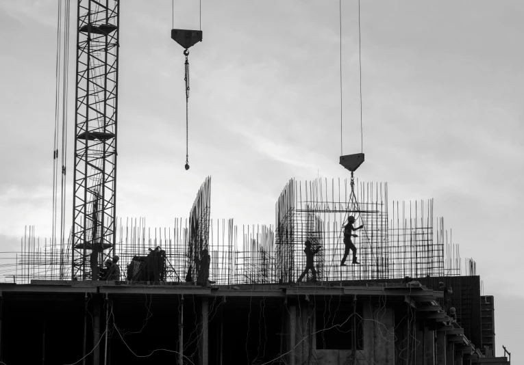 black and white pograph of construction cranes working