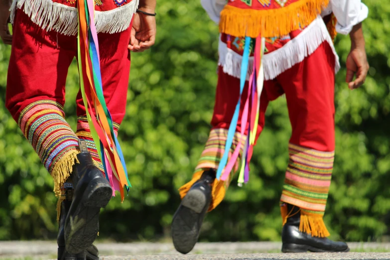 two people dressed in different colors holding colorful streamers