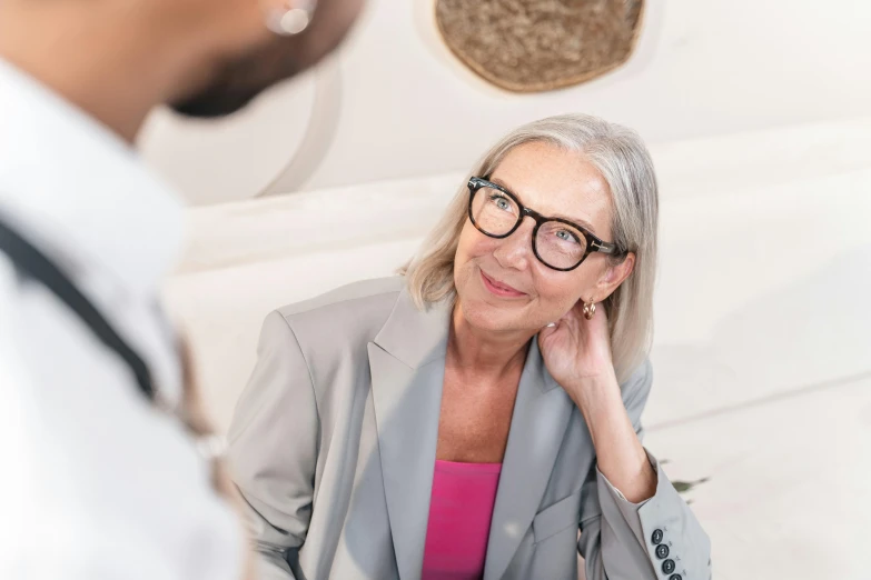 an older woman in glasses, talking to an old man