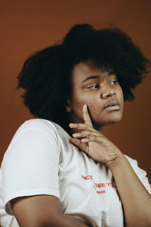 an image of a woman posing with her finger near her nose